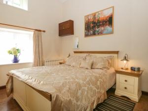 a bedroom with a large bed and a window at Topiary Cottage in Staveley