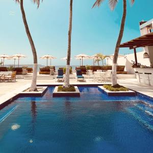 a swimming pool with palm trees in a resort at Wala beach club in Cartagena de Indias