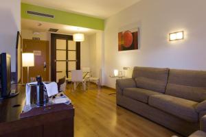 a living room with a couch and a table at Hotel La Boroña in Gijón