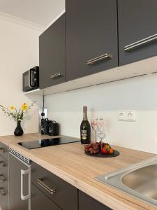 a kitchen with a bottle of wine and a plate of fruit at Schöne Souterrainwohnung in Seeshaupt in Seeshaupt
