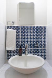 ein Badezimmer mit einem weißen Waschbecken und einem Spiegel in der Unterkunft Esencia Oaxaca in Oaxaca de Juárez