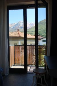 an open door to a balcony with a view of mountains at Picobello Lago in Mandello del Lario
