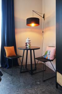 a table with a lamp and two chairs and a table with a lamp at Picobello Lago in Mandello del Lario