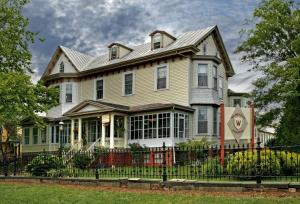 una casa grande con una valla delante en Wilbraham Mansion en Cape May