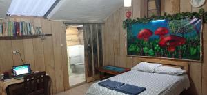 a bedroom with a bed and a painting of mushrooms at Cabaña de camping Villa Ernestina in Pasto