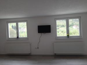 a white room with three windows and a flat screen tv at Apartman Dujmović in Visoko