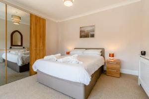 1 dormitorio con 2 camas y espejo en 1 Roxby Terrace en Thornton Dale