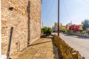 un muro di mattoni sul lato di una strada di 1 Roxby Terrace a Thornton Dale