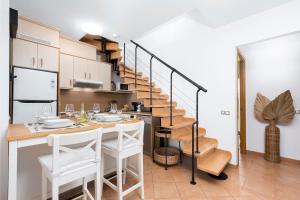 una cocina con una escalera de caracol con mesa y sillas en Villa Sofía Fuerteventura en Lajares