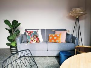 a living room with a blue couch with colorful pillows at Picobello Lago in Mandello del Lario