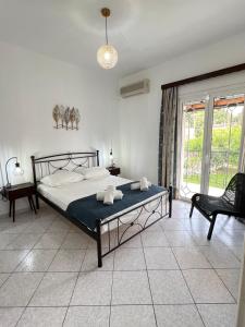 1 dormitorio con 1 cama, 1 silla y 1 ventana en Xanthi Apartments, en Sivota