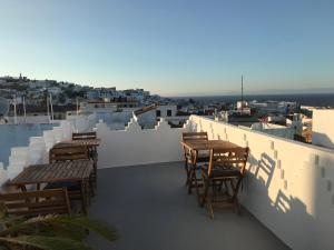 a balcony with tables and chairs and a view of a city at Dar 23 in Tangier