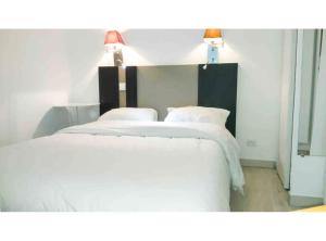 - une chambre avec 2 lits avec des draps et des lampes blancs dans l'établissement T2 A/C côte d'Azur, piscine, plage á 350m, WIFI, à Vallauris