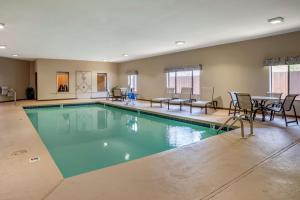 a large swimming pool with chairs and a table at Best Western Troy Inn in Troy