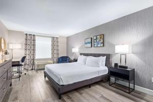 a hotel room with a bed and a desk and chair at Fountain Park Hotel BW Signature Collection in Fountain Hills +17 photos