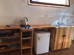 a kitchen with a sink and a white refrigerator at Cabañas Elquimista in Pisco Elqui