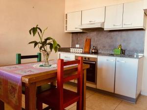 a kitchen with a wooden table with a vase on it at Balcones del boulevard in Mariano J. Haedo