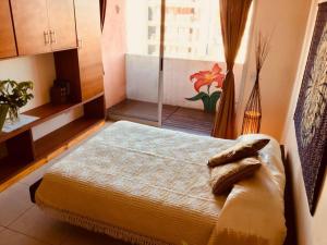 a bedroom with a bed and a window in a room at Balcones del boulevard in Mariano J. Haedo