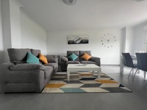 salon z dwiema kanapami i stołem w obiekcie Apartamentos María de Lucía-Piso 2º w mieście Arou