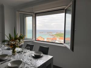 jadalnia ze stołem i dużym oknem w obiekcie Apartamentos María de Lucía-Piso 2º w mieście Arou