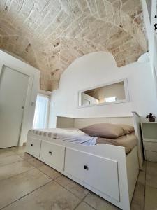 - une chambre avec un lit blanc et un plafond en pierre dans l'établissement Angoletto Bianco, à Ostuni