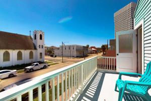 a balcony with a chair and a view of a street at Market Gem in Galveston