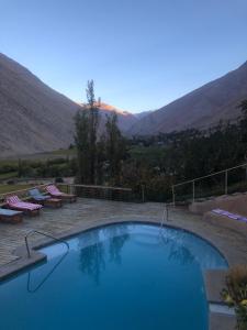 a large swimming pool with mountains in the background at Cabañas Elquimista in Pisco Elqui