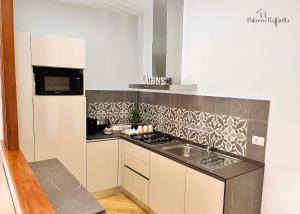 a kitchen with a sink and a stove at Appartamento Palazzo Raffaella in Castel SantʼElia