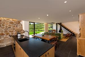 a kitchen and dining room with a stone wall at Casas Casal de Nino in Celorico de Basto