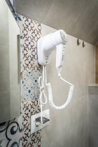 a white blow dryer is hanging in a bathroom at Apartamenty Hyrczyk in Ząb