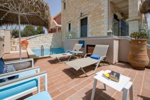 a patio with chairs and tables and a pool at Villa Constancia in Stalos