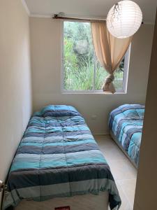 1 Schlafzimmer mit 2 Betten und einem Fenster in der Unterkunft departamentos tres habitaciones in La Serena