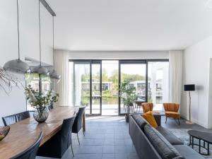 ein Wohnzimmer mit einem Tisch und einem Sofa sowie ein Esszimmer in der Unterkunft Attractive villa in Zeewolde with garden in Zeewolde