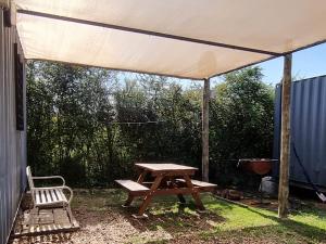 代曼的住宿－Complejo Containers DF，一张野餐桌和一张帐篷下的长凳