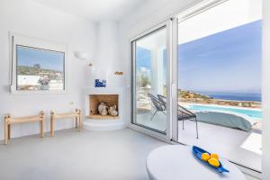 a white living room with a view of the ocean at Villa Mariel Skopelos in Skopelos Town