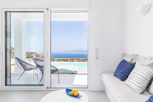 a living room with a white couch and a view of the ocean at Villa Mariel Skopelos in Skopelos Town +80 photos