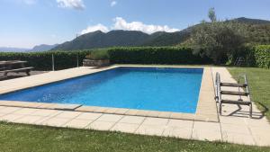 a swimming pool in a yard with a table and a bench at Apartaments Cal Borda in Coll de Nargó