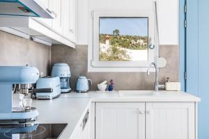 a kitchen with a sink and a window at Villa Mariel Skopelos in Skopelos Town
