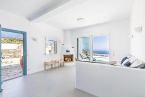 a white living room with a view of the ocean at Villa Mariel Skopelos in Skopelos Town