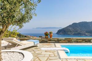 a pool with chairs and a view of the ocean at Villa Mariel Skopelos in Skopelos Town