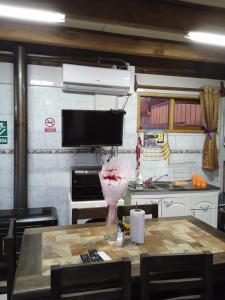 una cocina con una mesa con un jarrón. en Hostal Newen, en Villarrica