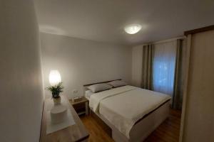 Un dormitorio con una cama y una mesa con una planta. en Vrlika, Peruća Lake Holiday House, en Vrlika