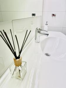 a bathroom sink with a vase with a plant in it at Götaströms Värdshus in Skillingaryd +12 photos