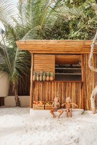 two dolls sitting on the sand in front of a building at Mahayana Tulum Beach Homes in Tulum