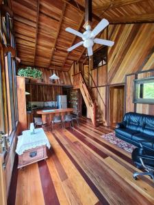 uma sala de estar com uma ventoinha de tecto e um sofá em Casa Numú em Cahuita