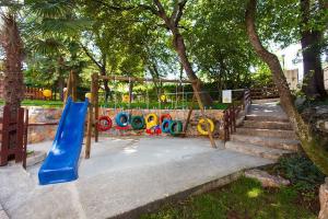 um parque infantil com um escorrega azul num parque em Apartments in Porec - Istrien 42535 em Porec