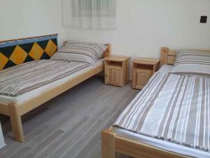 two beds in a room with two tables at Holiday home in Balatongyörök 42694 in Balatongyörök