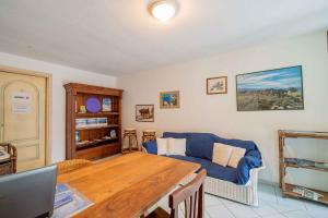a living room with a table and a blue couch at Holiday home in Monte Petrosu 42787 in Monte Petrosu