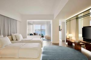 a living room with two beds and a television at Nikki Beach Resort & Spa in Porto Heli