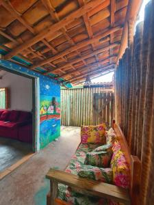 a living room with a couch and a wooden ceiling at Pousada Hospedaria Nativus Caraiva in Caraíva